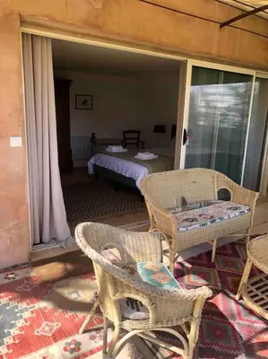 a room with a bed and chairs and a table at Le Jas Gabriel in Murs