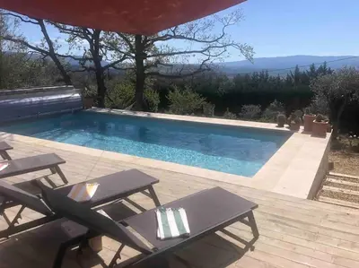 a swimming pool with two chairs and a table at Le Jas Gabriel in Murs