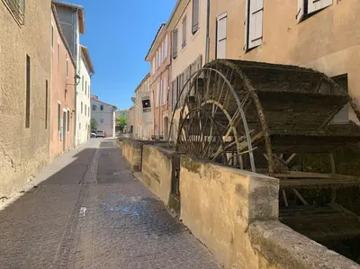an old bridge on a street next to a building at Joli appartement au cœur de la ville in LʼIsle-sur-la-Sorgue