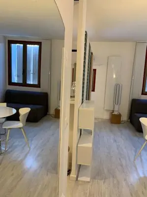 a living room with a couch and a table and chairs at Joli appartement au cœur de la ville in LʼIsle-sur-la-Sorgue