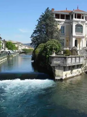 a bridge over a river in a city with buildings at Joli appartement au cœur de la ville in LʼIsle-sur-la-Sorgue