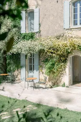 a table and chairs in front of a building at La Bastide du Mourre - Fontenille Collection in Oppède
