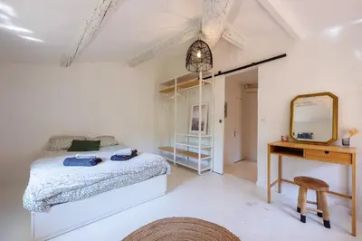 a bedroom with a bed and a desk and a mirror at L'Aixquis - T2, Vieille Ville in Aix-en-Provence