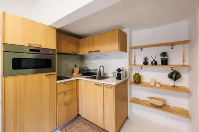 a kitchen with wooden cabinets and a sink at L'Aixquis - T2, Vieille Ville in Aix-en-Provence