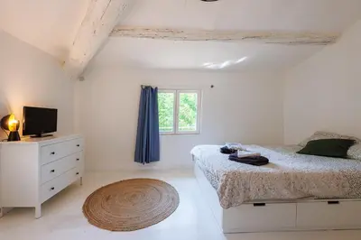 a white bedroom with a bed and a window at L'Aixquis - T2, Vieille Ville in Aix-en-Provence