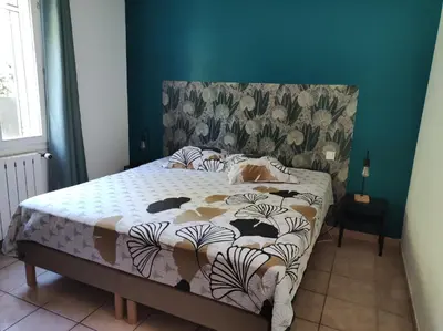 a bed in a bedroom with a blue wall at Maison provençale in Pernes-les-Fontaines