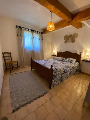 a bedroom with a bed with a blue comforter at Gîte Lou Gardian in Aureille