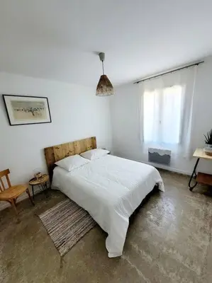 a white bedroom with a large bed and a window at Maison de village 4 étoiles avec piscine privee in Villars