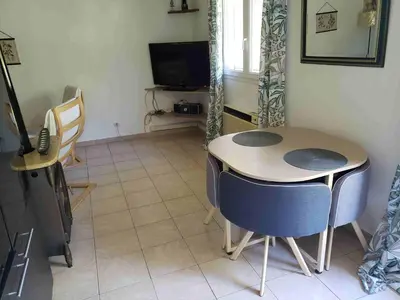 a room with a table and chairs and a television at Charmante petite maison de campagne in Jouques