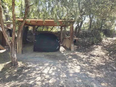 a tent under a wooden shelter under a tree at Charmante petite maison de campagne in Jouques