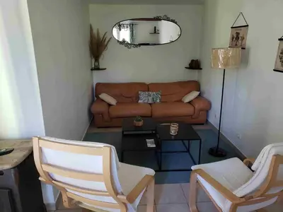 a living room with a couch and a table and chairs at Charmante petite maison de campagne in Jouques