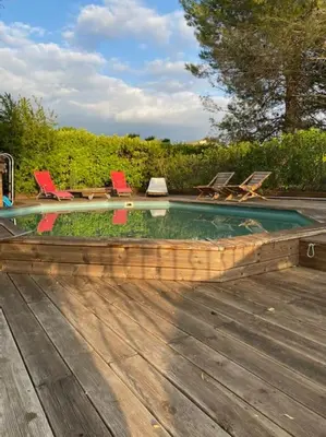 a swimming pool with chairs and a bunch ofitures at Maison familiale au pied du Mont Ventoux in Mazan