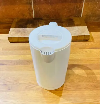 a white trash can sitting on a wooden floor at Aix-en-Provence, studio atypique quartier hyper centre in Aix-en-Provence
