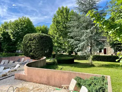 a row of white chairs sitting in a garden at Notre Dame des Anges DUPLEX in Rustrel