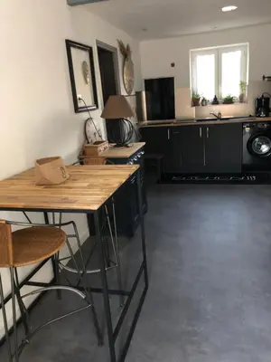 a kitchen with black cabinets and a wooden table at Ferigoules #festivalavignon in Entraigues-sur-la-Sorgue