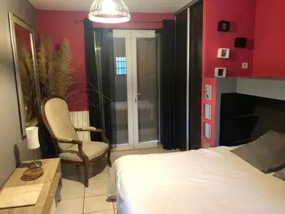 a bedroom with red walls and a bed and a chair at Ferigoules #festivalavignon in Entraigues-sur-la-Sorgue