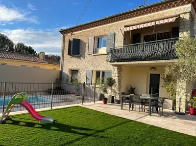 a house with a lawn with a slide in the yard at La villa castellas in Carpentras