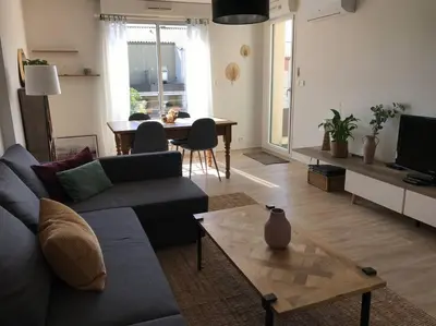 a living room with a couch and a table at Charmant appartement ensoleillé-Terrasse - PARKING Gratuit - Isle sur la Sorgue in LʼIsle-sur-la-Sorgue