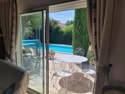 a glass door with a table and chairs on a patio at La Villa des Lavandes - A 300m du Centre, au calme, et au vert ! in LʼIsle-sur-la-Sorgue