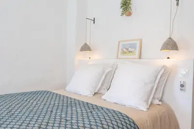 a bedroom with a bed with white pillows at Chez Fanny in Bédoin