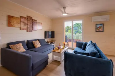 a living room with two blue couches and a table at L'Oliveraie in Saint-Saturnin-les-Apt