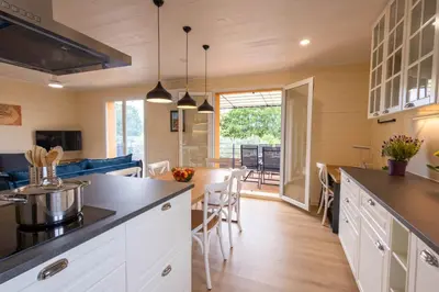 a kitchen and living room with a table and chairs at L'Oliveraie in Saint-Saturnin-les-Apt
