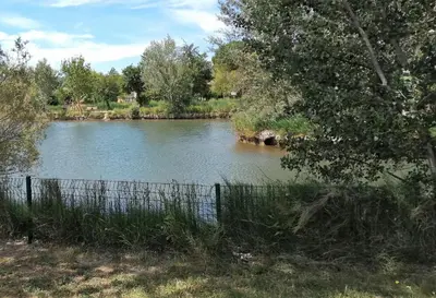 a body of water with a fence next to it at chez bruno et marie jo in Saint-Saturnin-lès-Avignon