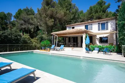 a villa with a swimming pool in front of a house at Villa climatisée avec vue en pleine pinède aixoise in Saint-Marc-Jaumegarde