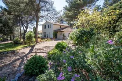 a house with a garden with purple flowers at Villa climatisée avec vue en pleine pinède aixoise in Saint-Marc-Jaumegarde
