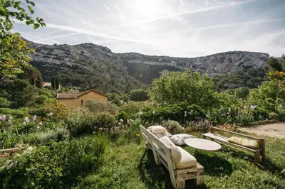 a bench in a field with mountains in the background at Hidden gem with panoramic views in Fontaine-de-Vaucluse