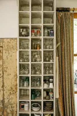 a cabinet filled with glass jars and plates at Hidden gem with panoramic views in Fontaine-de-Vaucluse