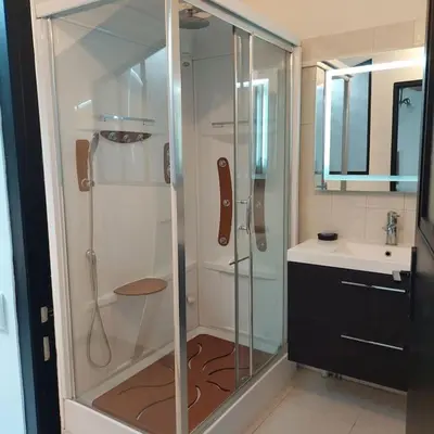 a bathroom with a glass shower and a sink at Mon Ventoux in Modène