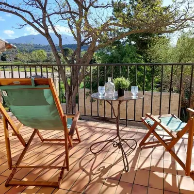 a patio with a table and a chair on a deck at Mon Ventoux in Modène