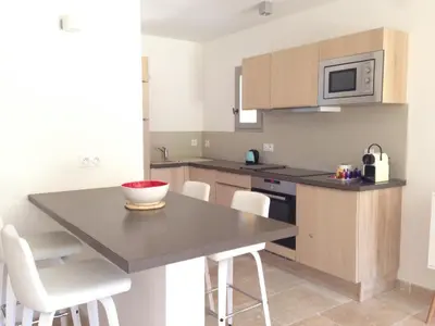 a kitchen with a table with chairs and a microwave at La Grande Bouisse gites avec piscine dans le Luberon, Provence in Céreste