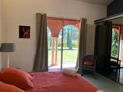 a bedroom with a bed and a large window at Petite Toscane Villa close to Aix en Provence in Ventabren