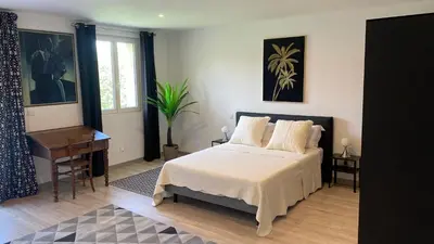 a bedroom with a bed and a table and a window at Résidence Soleado Maison jumelée à 800m du centre ville de Bédoin in Bédoin