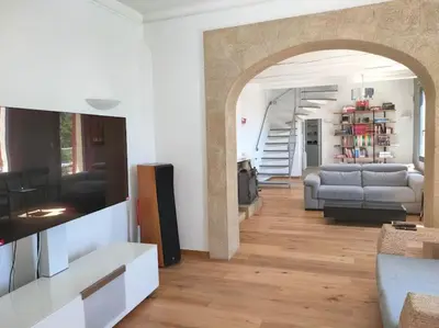 a living room with a couch and a tv in a room at Bastide vue exceptionnelle in Aix-en-Provence