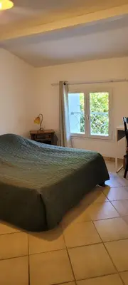 a bedroom with a bed and a window at Mas provençal in Sénas