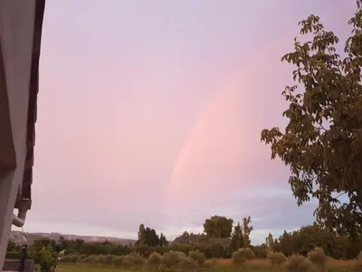 a rainbow in the sky over a field at Mas provençal in Sénas