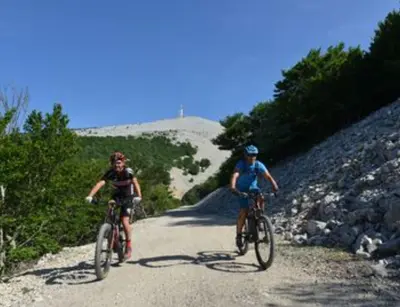 two people riding bikes down a dirt road at Le logis du Ventoux in Bédoin