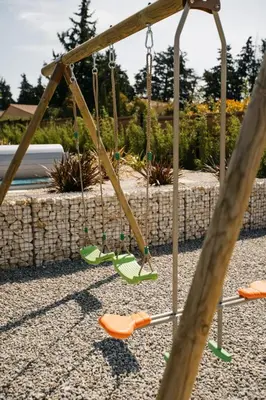 a swing set with orange and green swings at Villa Moka - private pool in Saumane-de-Vaucluse