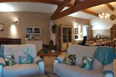 a living room with two white couches and a table at Le Mas des Cigales avec parc et grande piscine in Velleron