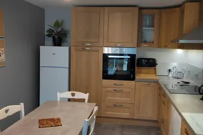 a kitchen with wooden cabinets and a white refrigerator at Le Mas des Cigales avec parc et grande piscine in Velleron