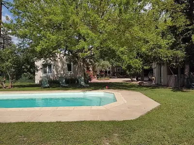 a swimming pool in the yard of a house at Le Mas des Cigales avec parc et grande piscine in Velleron