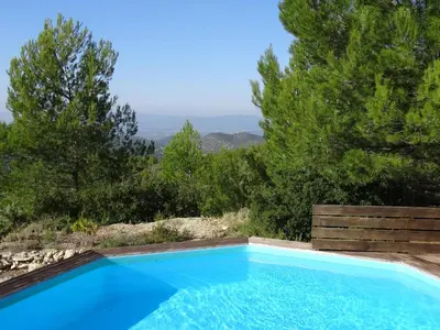 a blue swimming pool with a view of trees at Soleil bleu in Rognes