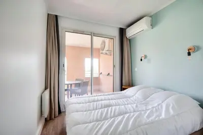 a white bed in a room with a window at Village Pont Royal en Provence - maeva Home - Appartement cosy et climatisé 2 pièces 4 personnes - Sélection - super Home MAE-2154 in Mallemort