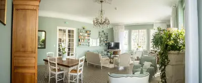 a living room with a table and chairs and a dining room at Demeures et Châteaux Hôtel L'Hermitage in Pernes-les-Fontaines
