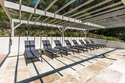 a group of chairs sitting under a pergola at Villa Les Cigales Velaux in Velaux