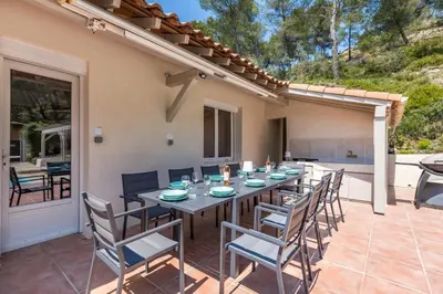 a patio with a table and chairs on a patio at Villa Les Cigales Velaux in Velaux