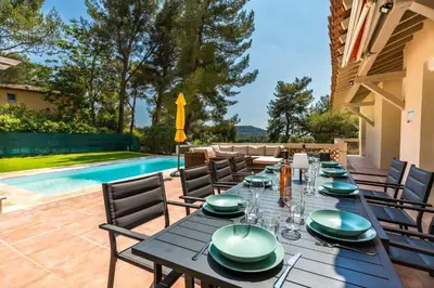a dining table with plates and napkins on a patio at Villa Les Cigales Velaux in Velaux